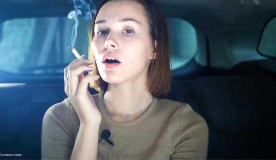 Beautiful Yulia is smoking with only nose exhales in the car