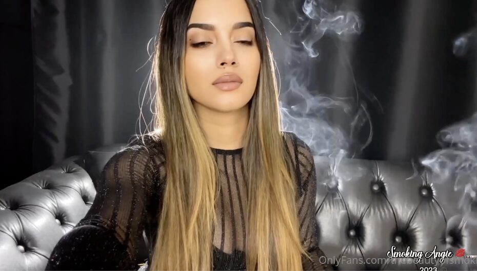 Dangling a white 100s cigarette – Angie