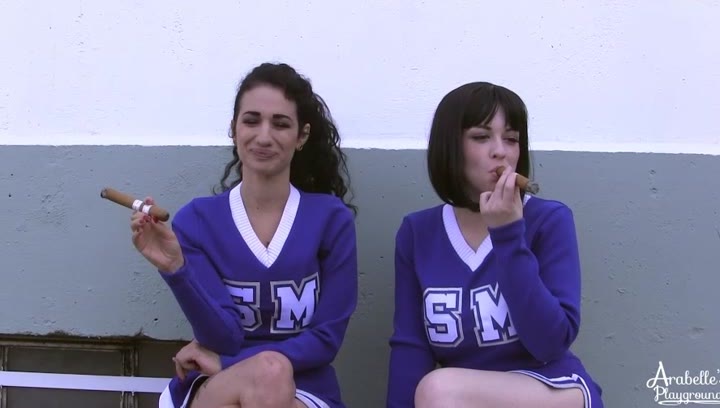 Two Cheerleaders Smoking Big Cigars in a very Sexy and Sensual way