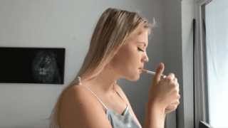 Young blonde smokes to a long stub