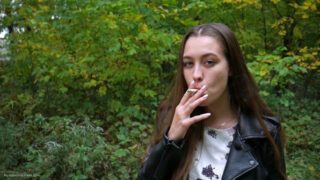Russian Girl Smokes at cigarette in the Wood